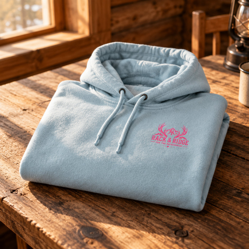 A light blue pullover hoodie with a small pink graphic on the left chest 